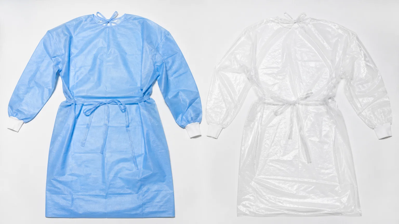 Blue CPE and clear PE isolation gowns compared side by side on a white surface